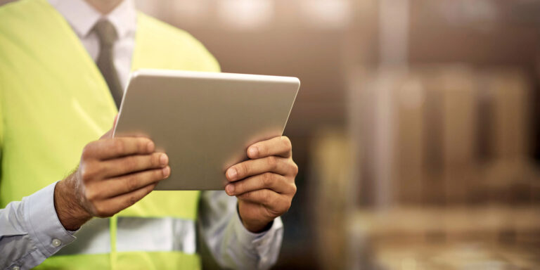 Closeup shot of an unrecognisable man working on a digital tablet in a distribution warehouse