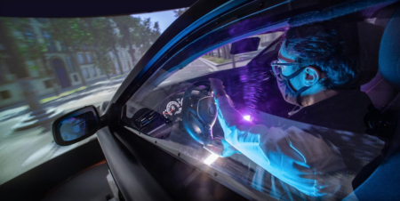 a man turning the steering wheel in a driving simulator