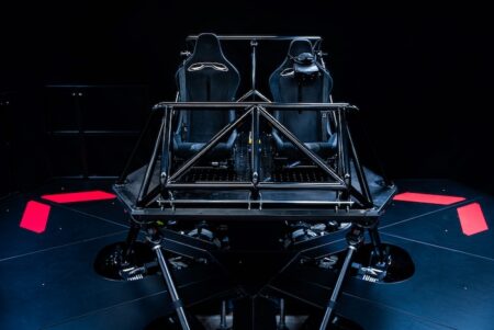 TU Graz’s Advanced Driving Simulation Centre acquires DMG-X driving simulator Dynisma DMG-X driving simulator with dual racing seats mounted on a hexapod motion platform with pink accent panels against a dark background